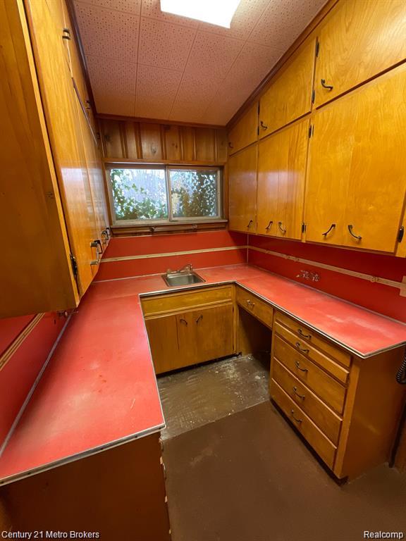 106 N Marquette St, Durand, MI 48429 - kitchen with brown cabinets and concrete floors