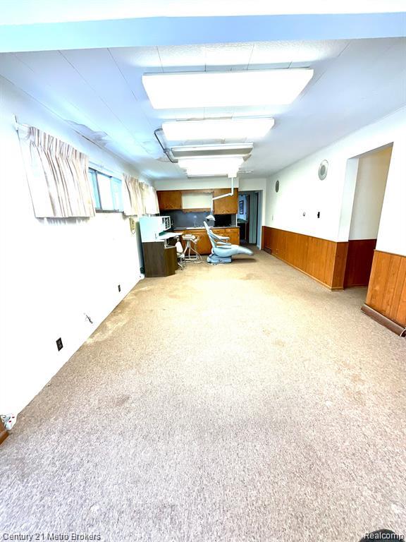 106 N Marquette St, Durand, MI 48429 - interior space with wainscoting, carpet floors, and wood walls