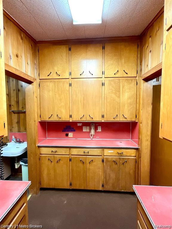 106 N Marquette St, Durand, MI 48429 - kitchen with brown cabinets and finished concrete floors