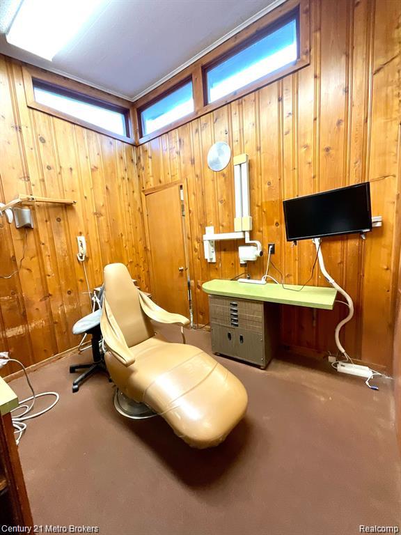 106 N Marquette St, Durand, MI 48429 - sitting room featuring healthy amount of natural light, wooden walls, and concrete flooring