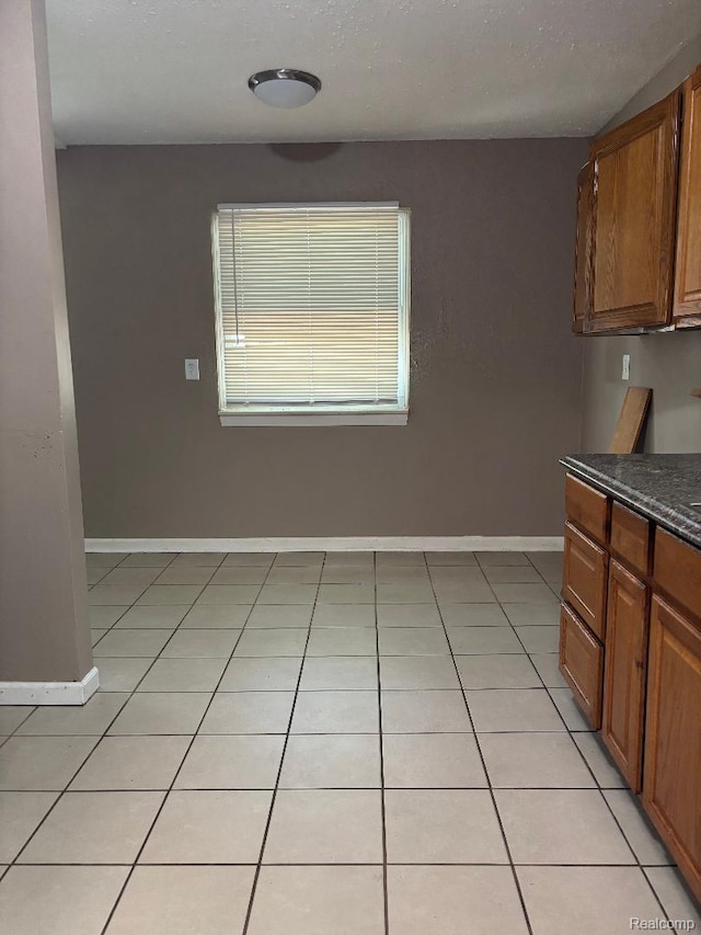 6303 Duncan St, Taylor, MI 48180 - kitchen with dark countertops, light tile patterned flooring, and brown cabinets