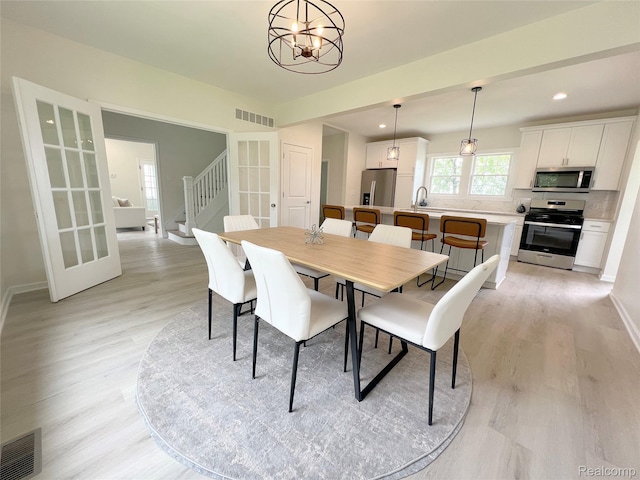 19904 Mckinnon St, Roseville, MI 48066 - dining space with light wood-style floors, recessed lighting, a chandelier, and stairway