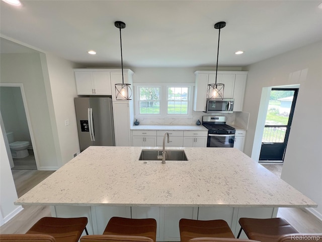 19904 Mckinnon St, Roseville, MI 48066 - kitchen with appliances with stainless steel finishes, a kitchen breakfast bar, light stone countertops, light wood-type flooring, and recessed lighting