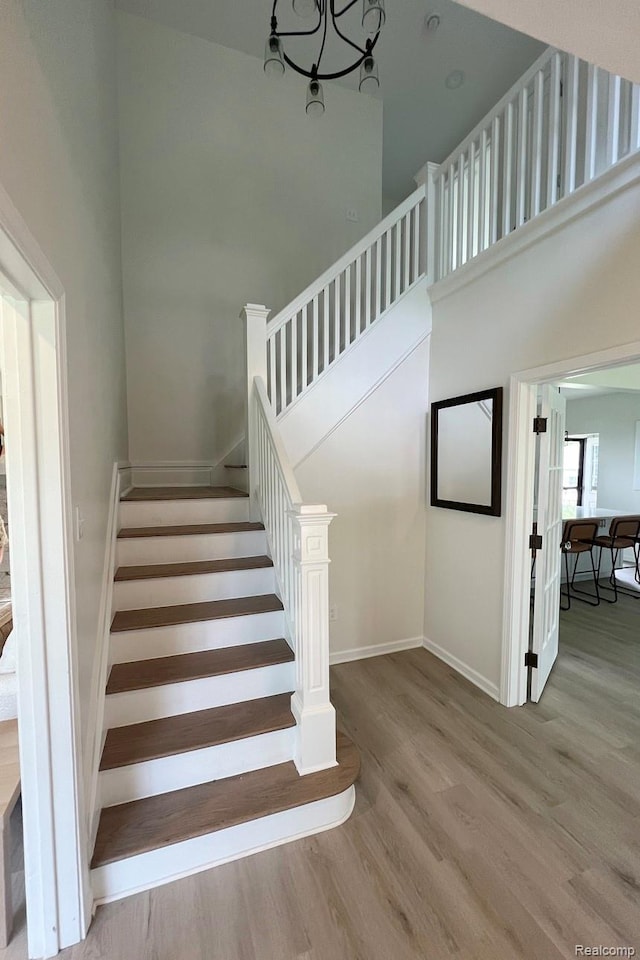 19904 Mckinnon St, Roseville, MI 48066 - staircase featuring wood finished floors, a chandelier, and a towering ceiling