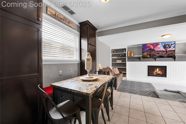 22086 Hillcrest Ct, Woodhaven, MI 48183 - dining area with light tile patterned floors, built in features, and a glass covered fireplace