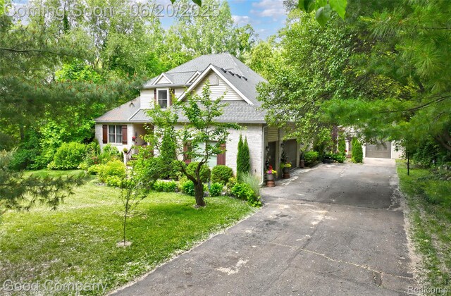 115 Audubon Dr, White Lake, MI 48383 - view of front of property featuring driveway, a front yard, roof with shingles, and brick siding