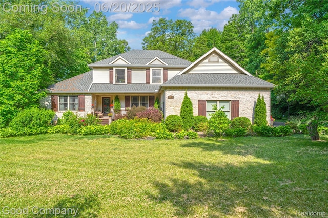 115 Audubon Dr, White Lake, MI 48383 - traditional-style home with a front yard, a shingled roof, and brick siding