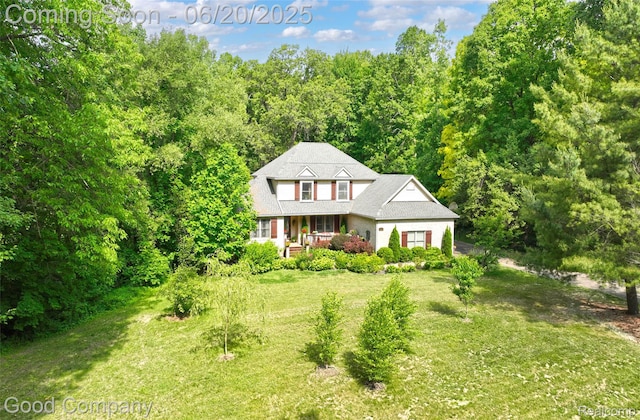 115 Audubon Dr, White Lake, MI 48383 - traditional home featuring a front yard, a view of trees, and a porch