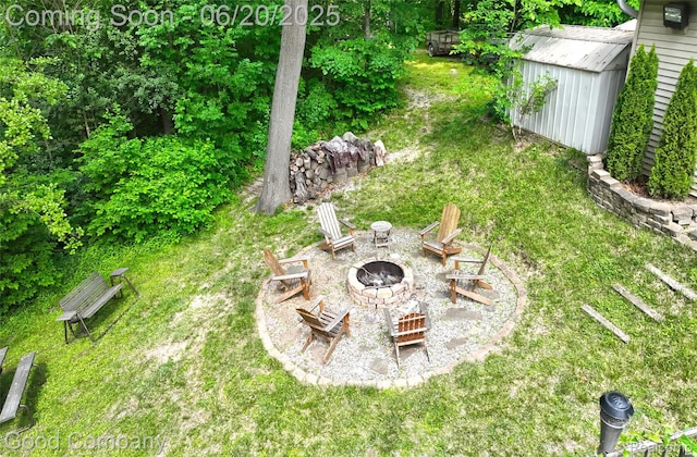 115 Audubon Dr, White Lake, MI 48383 - view of grassy yard with an outdoor fire pit and an outdoor structure