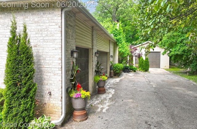 115 Audubon Dr, White Lake, MI 48383 - view of home's exterior featuring an outdoor structure and brick siding