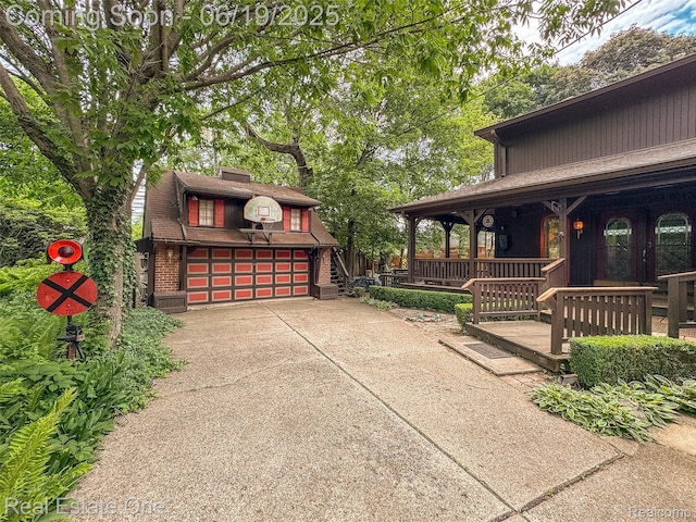 26044 York Rd, Huntington Woods, MI 48070 - covered porch featuring a garage, an outbuilding, and driveway