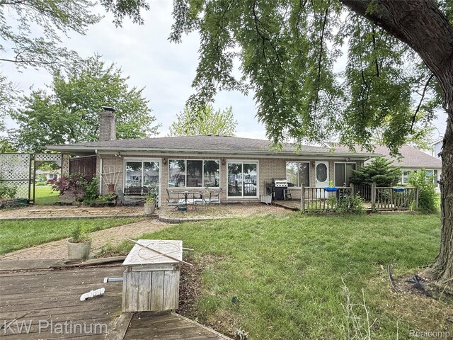 7275 Bluebill St, Clay, MI 48001 - back of property featuring a chimney, brick siding, a wooden deck, and a gate