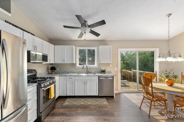704 Pecan Ct NW, Grand Rapids, MI 49504 - kitchen featuring appliances with stainless steel finishes, white cabinetry, dark wood finished floors, and light stone counters