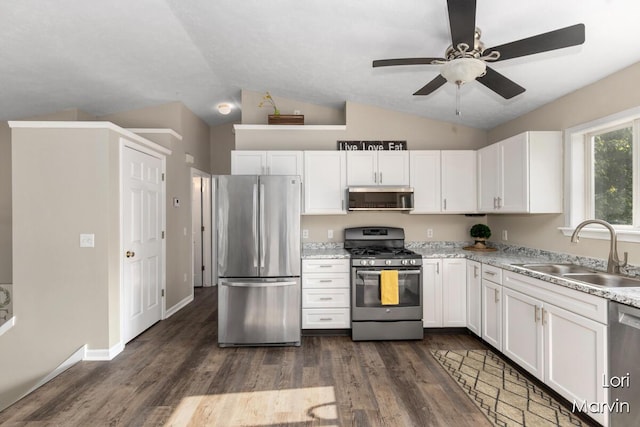 704 Pecan Ct NW, Grand Rapids, MI 49504 - kitchen with appliances with stainless steel finishes, white cabinetry, vaulted ceiling, and dark wood-style flooring