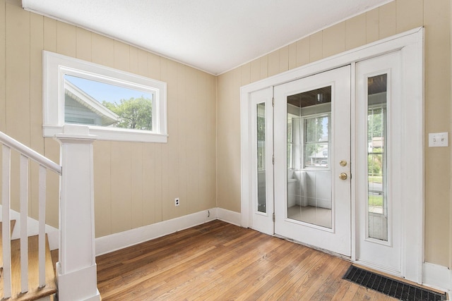 258 Richards Ave SW, Grand Rapids, MI 49504 - entryway with light wood finished floors, healthy amount of natural light, stairs, and wood walls