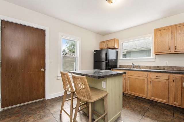 258 Richards Ave SW, Grand Rapids, MI 49504 - kitchen with freestanding refrigerator, dark countertops, a kitchen bar, and a center island