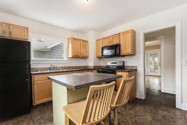258 Richards Ave SW, Grand Rapids, MI 49504 - kitchen with black appliances, dark countertops, a kitchen island, and a kitchen breakfast bar