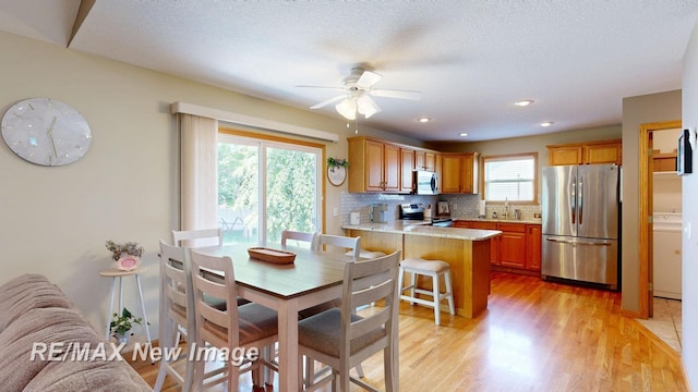 3137 Sundown Ln, Saginaw, MI 48603 - dining area featuring a ceiling fan, light wood-style flooring, washer / clothes dryer, and recessed lighting