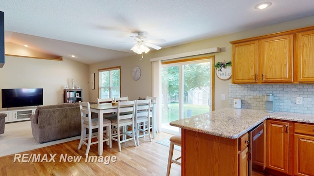 3137 Sundown Ln, Saginaw, MI 48603 - kitchen featuring ceiling fan, backsplash, light wood-style flooring, vaulted ceiling, and light stone countertops