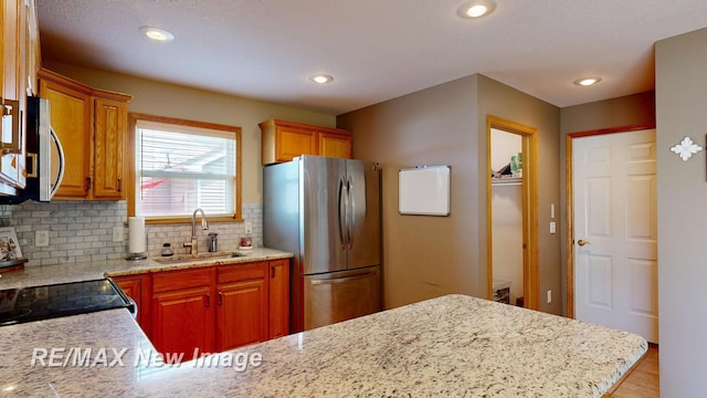 3137 Sundown Ln, Saginaw, MI 48603 - kitchen featuring stainless steel appliances, tasteful backsplash, recessed lighting, light stone countertops, and a peninsula
