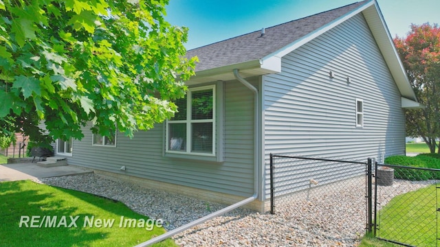3137 Sundown Ln, Saginaw, MI 48603 - view of property exterior featuring roof with shingles, entry steps, a patio area, and a gate
