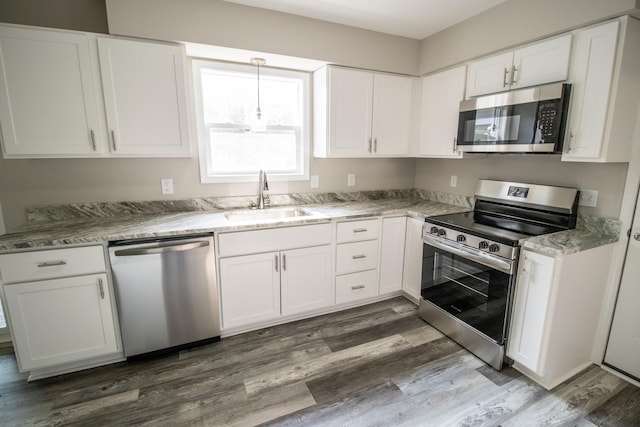 9461 Morrish Rd, Montrose, MI 48457 - kitchen featuring appliances with stainless steel finishes, dark wood finished floors, white cabinets, and light stone countertops