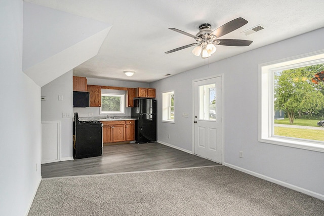 5747 Utah Ave, Portage, MI 49024 - kitchen featuring freestanding refrigerator, gas range, brown cabinetry, ceiling fan, and open floor plan