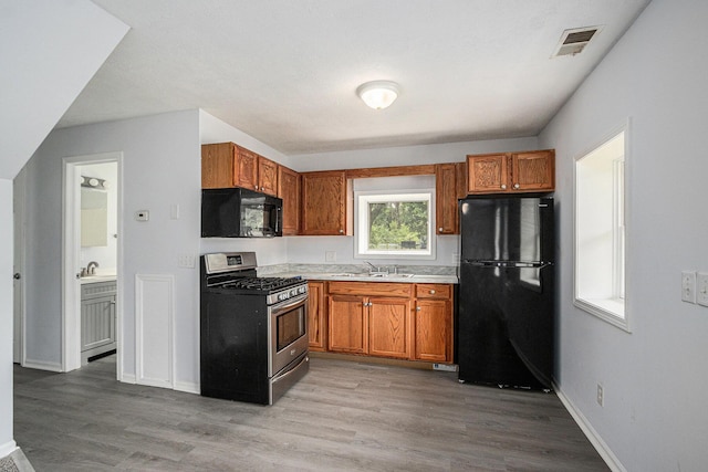 5747 Utah Ave, Portage, MI 49024 - kitchen featuring black appliances, wood finished floors, and brown cabinets