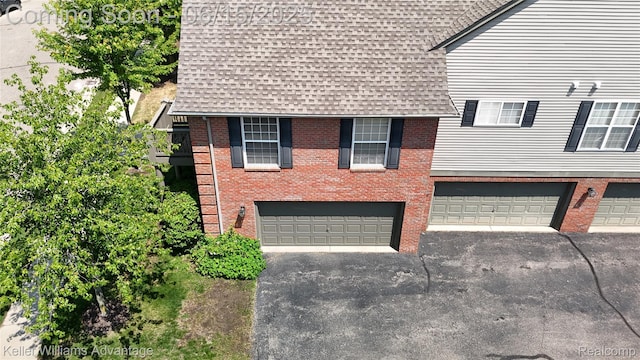 28498 Carlton Way Dr, Novi, MI 48377 - view of front of home featuring a shingled roof, driveway, an attached garage, and brick siding