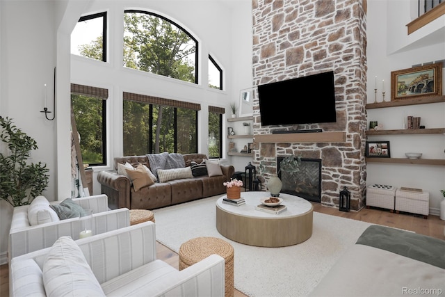 2584 Heights View Ct, Rochester, MI 48306 - living room featuring a high ceiling, a stone fireplace, and wood finished floors