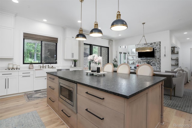 2584 Heights View Ct, Rochester, MI 48306 - kitchen featuring stainless steel microwave, light wood-style floors, open floor plan, recessed lighting, and a kitchen island