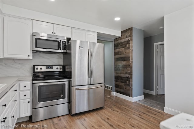 1330 Rahn St, Westland, MI 48186 - kitchen with appliances with stainless steel finishes, white cabinets, recessed lighting, light wood-style floors, and light countertops
