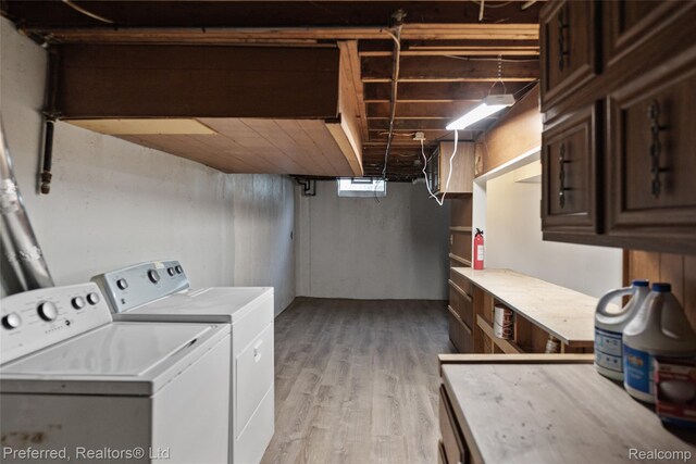 1330 Rahn St, Westland, MI 48186 - laundry room with washing machine and dryer, light wood-style floors, and cabinet space
