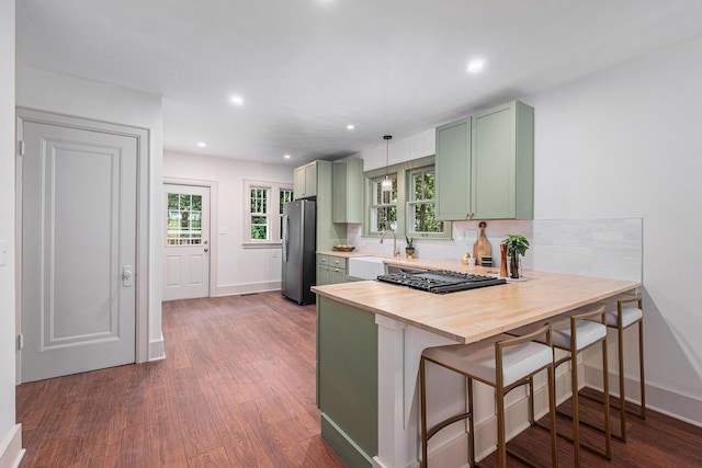 1412 4th St NW, Grand Rapids, MI 49504 - kitchen featuring green cabinets, freestanding refrigerator, dark wood-type flooring, a peninsula, and recessed lighting