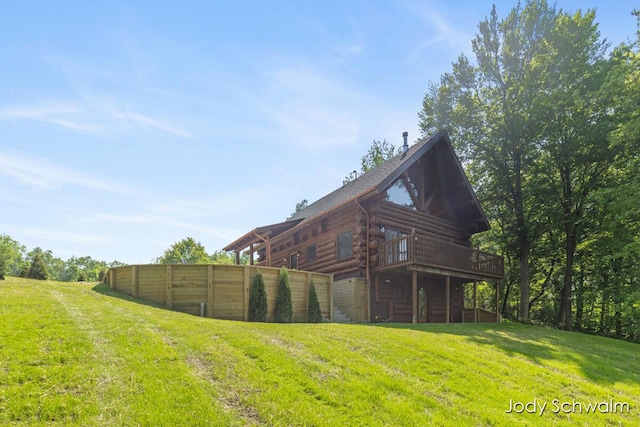 5820 Grace Hwy, Sunfield, MI 48890 - back of house with a deck, log siding, and a lawn