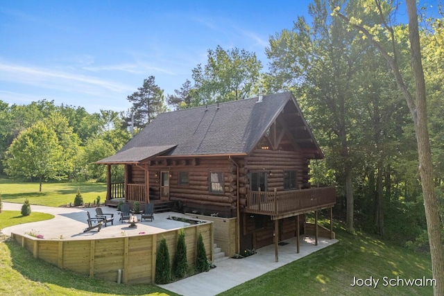 5820 Grace Hwy, Sunfield, MI 48890 - rear view of house featuring a patio area, a yard, an outdoor fire pit, a wooden deck, and log exterior