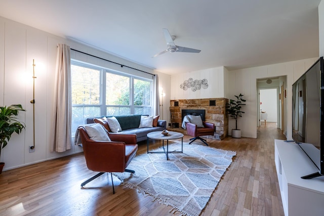 212 N Maple St, Saugatuck, MI 49453 - living room with light wood finished floors, a decorative wall, a fireplace, and ceiling fan