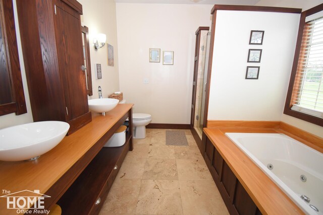2411 Escott Rd, Owosso, MI 48867 - full bathroom with a tub with jets, double vanity, a shower stall, and stone finish floors