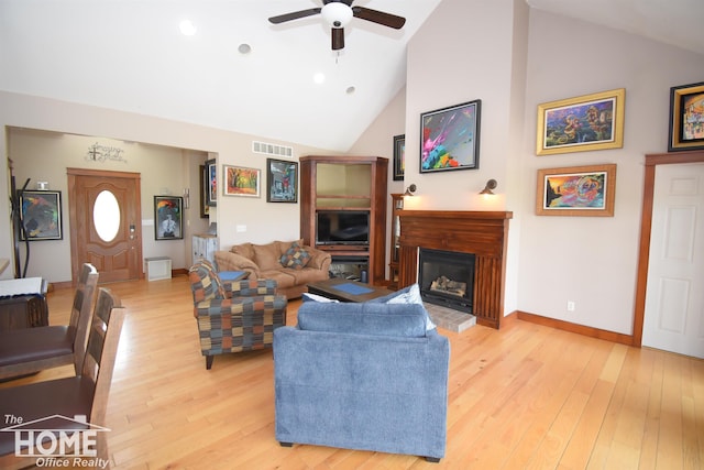 2411 Escott Rd, Owosso, MI 48867 - living area featuring a ceiling fan, light wood-style floors, a glass covered fireplace, and high vaulted ceiling