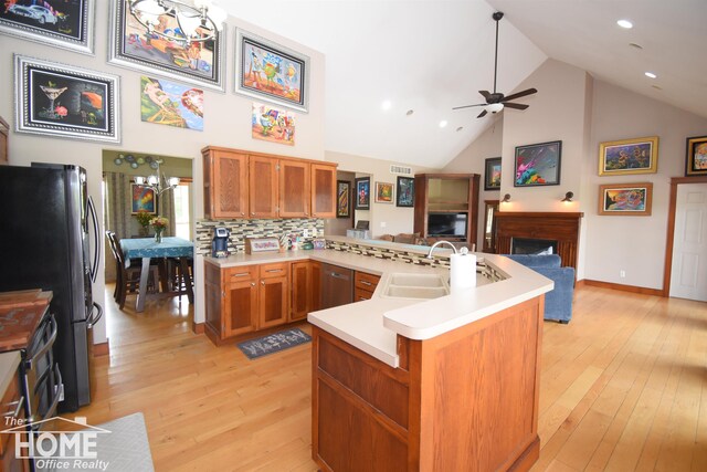 2411 Escott Rd, Owosso, MI 48867 - kitchen featuring stainless steel appliances, light wood-type flooring, a peninsula, a ceiling fan, and brown cabinets