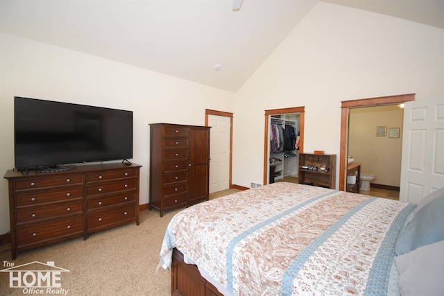 2411 Escott Rd, Owosso, MI 48867 - bedroom with high vaulted ceiling, a spacious closet, a closet, light carpet, and connected bathroom