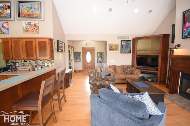 2411 Escott Rd, Owosso, MI 48867 - living room featuring light wood-style flooring, high vaulted ceiling, recessed lighting, and a fireplace with raised hearth