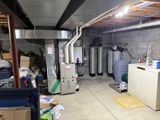 11199 Edgewood Rd, Bellevue, MI 49021 - unfinished below grade area with washing machine and dryer, heating unit, a water softener system, and refrigerator