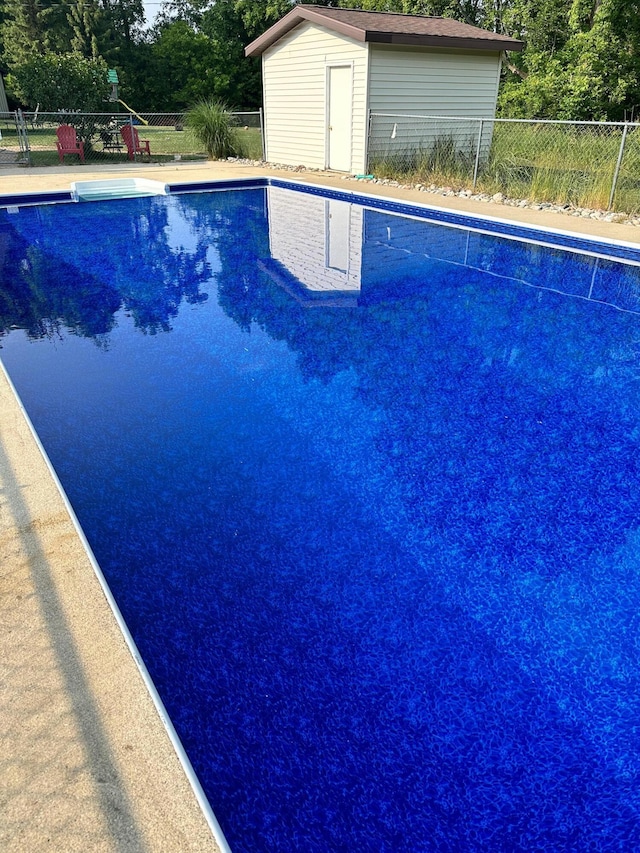 11199 Edgewood Rd, Bellevue, MI 49021 - view of swimming pool with a storage unit and view of wooded area