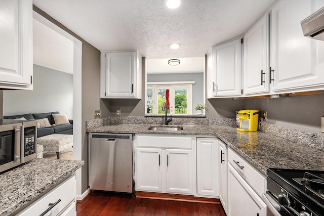 3395 Breckland Ct, Ann Arbor, MI 48108 - kitchen featuring appliances with stainless steel finishes, white cabinets, dark wood-style floors, a textured ceiling, and stone countertops