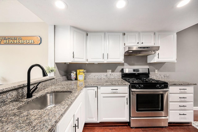3395 Breckland Ct, Ann Arbor, MI 48108 - kitchen with under cabinet range hood, stainless steel gas range, stone counters, dark wood-type flooring, and white cabinets