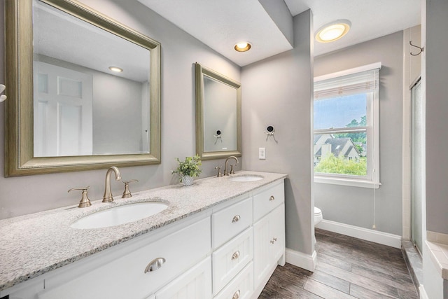 3395 Breckland Ct, Ann Arbor, MI 48108 - bathroom featuring double vanity, wood finished floors, and a shower with shower door