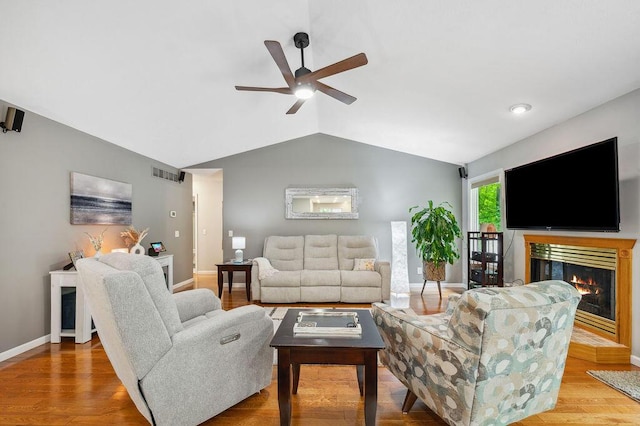 3999 Ravina Ter, Saint Joseph, MI 49085 - living area featuring a glass covered fireplace, lofted ceiling, a ceiling fan, and wood finished floors