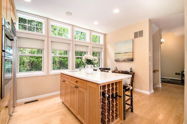 18418 Dunecrest Dr Unit 9, New Buffalo, MI 49117 - kitchen with light brown cabinetry, light wood finished floors, a kitchen island with sink, light countertops, and recessed lighting