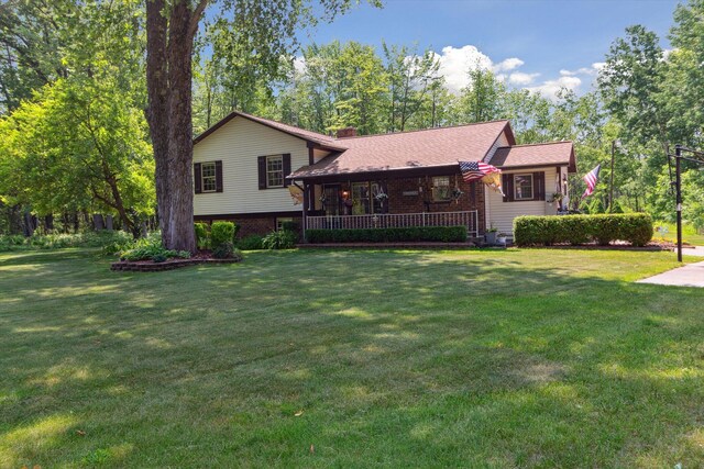 10343 N Walnut Ave, Bitely, MI 49309 - tri-level home with a front lawn, covered porch, a chimney, and brick siding